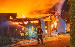 Ein Feuerwehrmann löscht einen Brand in Kehl-Neumühl