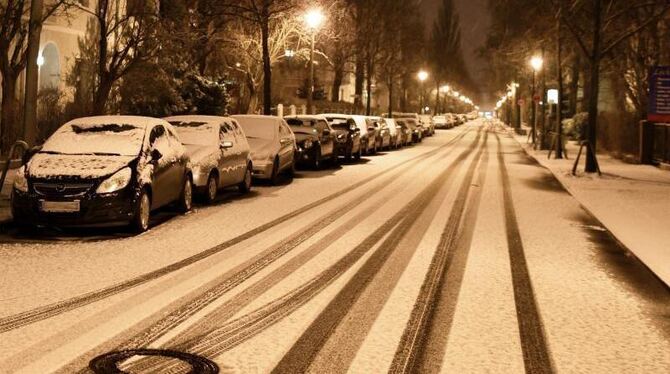 Schnee bedeckt in der Nacht in Berlin Karlshorst parkende Autos und die Straßen. Foto: Jens Kalaene