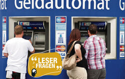 Kunden stehen an Bankautomaten.