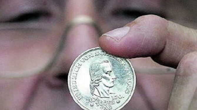 Schillernd: Manfred Reusch begutachtet die Schiller-Münze aus dem Jahr 1955 ganz genau.
FOTO: REISNER Schillernd: Manfred Reusch begutachtet die Schiller-Münze aus dem Jahr 1955 ganz genau.
FOTO: REISNER