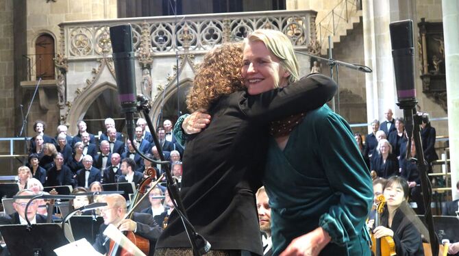 Dirigentin Annedore Neufeld und Komponistin Mari Vihmand (im grünen Kleid) umarmen einander nach der Aufführung von Vihmands Wer
