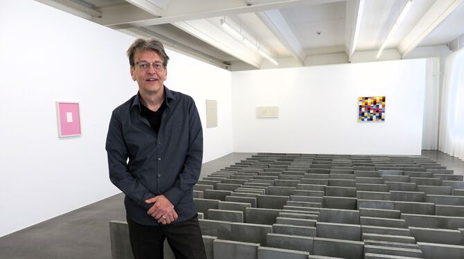 Ausstellungsmacher Holger Kube Ventura vor einem Werk aus Gehwegplatten von Hartmut Böhm.