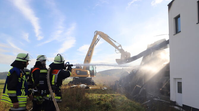 Die Engstinger Feuerwehr bekämpft den Brand. Ein Bagger reißt die von der Hitze verbogenen Stahlwände ein.