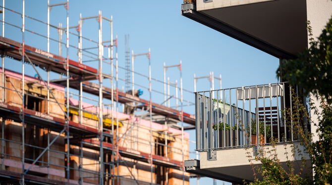 Politik,Wohnungspolitik,Neubau,Baustelle,Bauen,Baugerüst,Wohnungsmarkt,Wohnhaus,Wohnungsbau,Bauland,Bauarbeiten,Mieten,Miete,Gru Ein Gerüst steht an der Baustelle eines Neubaus. Neben der Baustelle steht ein bereits fertiggestellter Neubau.