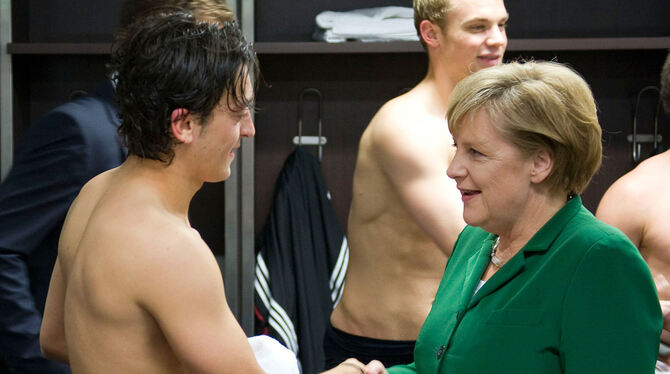 Bundeskanzlerin Angela Merkel gratuliert Nationalspieler Mesut Özil 2010 nach dem UEFA 2012-Qualifikationsspiel Deutschland gege