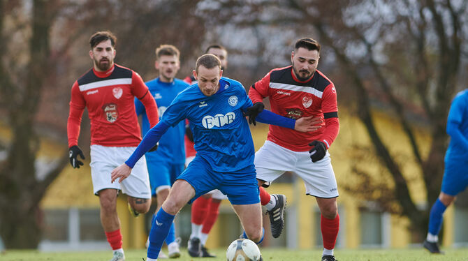 Florian Komenda (im blauen Trikot) vom SV Walddorf wird von Anadolu-Akteur Mert Demirel attackiert.