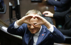 Donald Tusk formt nach seiner Wahl zum polnischen Premierminister im Parlament ein Herz mit seinen Händen. 