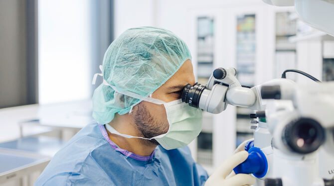 Augenchirurg Konstantinos Gklavas am OP-Mikroskop.
