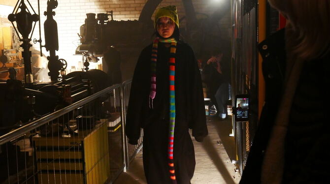 Leuchtender Schal und Maschinenschatten: Darstellerin beim Event »Détournement« im Indutriemagazin.