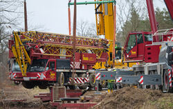 Bis zu einem knappen Meter hoch hängt der havarierte Autokran an den Trageketten zweier weiterer Kräne.