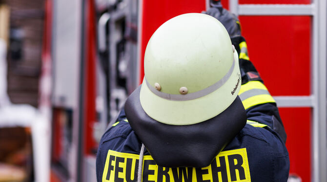 Baden-Württemberg, Staufen: Ein Feuerwehrmann holt während einer Einsatzübung einer Freiwilligen Feuerwehr eine Leiter vom Dach