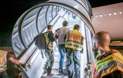  Polizisten begleiten einen abgelehnten Asylbewerber in ein Flugzeug. Er soll in sein Herkunftsland abgeschoben werden.  FOTO: K