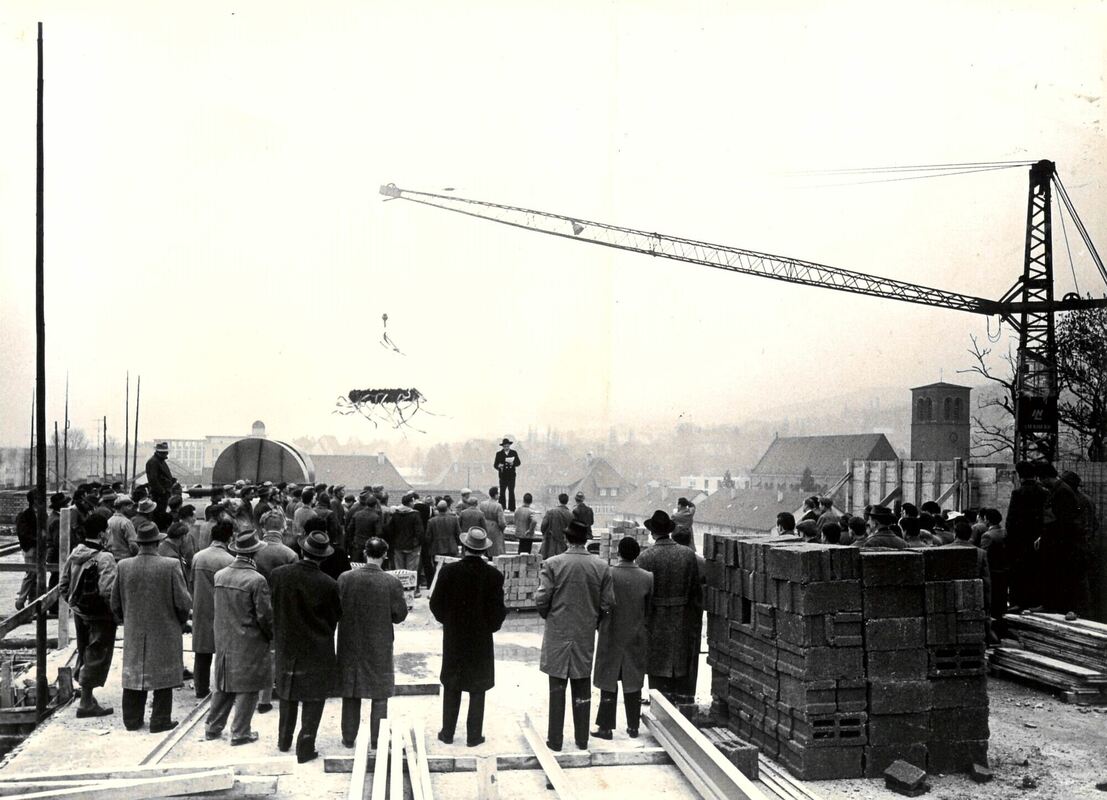 19.03.1960 - Bald fällt der Bauzaun am Erweiterungsbau des Kaufhauses Merkur. In luftiger Höhe wurde der Zimmermannsspruch gehal