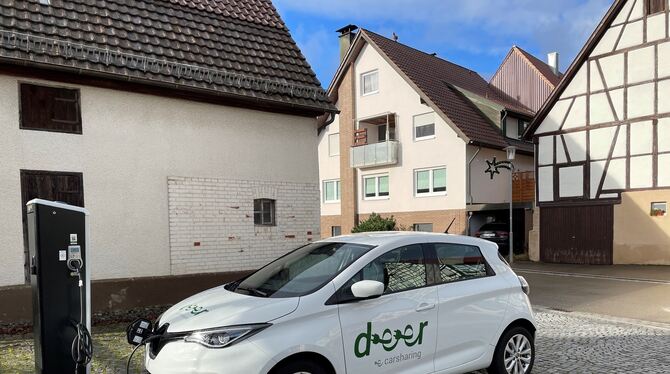 Ein Auto des Car-Sharing-Anbieters Deer steht an einer Ladesäule vor dem Rathaus von Häslach und wird gerade geladen.