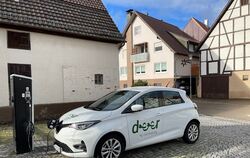 Ein Auto des Car-Sharing-Anbieters Deer steht an einer Ladesäule vor dem Rathaus von Häslach und wird gerade geladen.