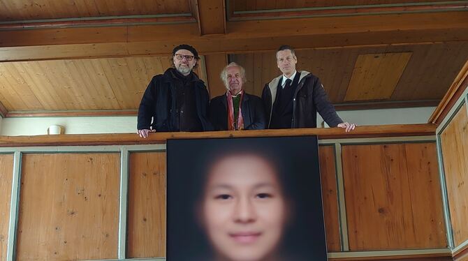 Anton Zirkelbach, Wolf Nkole Helzle und Pfarrer Martin Breitling (von links)  über dem »Gesicht der Menschheit«.