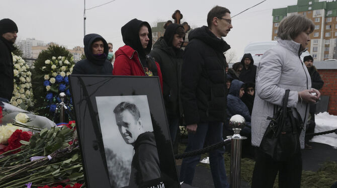 Menschen gehen während der Beerdigungszeremonie auf dem Friedhof Borisowskoje an einem Porträt des russischen Oppositionellen A