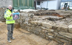 Vor der rund 12 Meter langen Fundamentseite des quadratischen Burgturms zeigt Ausgäber Gerd Stegmaier wie die Jettenburger Anlag