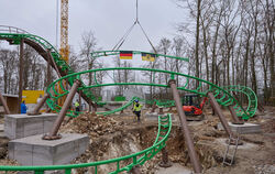 Schiene im Anflug: Das letzte fehlende Stück der neuen Achterbahn im Traumland bei der Bärenhöhle wird eingesetzt. Die Flaggen a