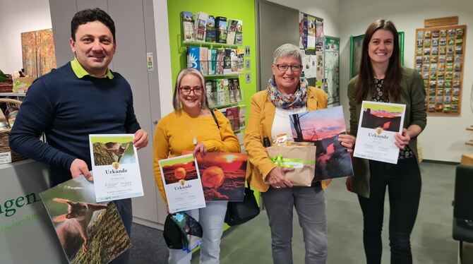 Hans-Peter Engelhart (links) und Anke Schmid (rechts) von der Münsinger Touristik Information überreichten Carmen Goller (zweite