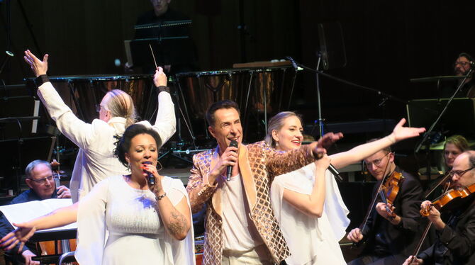 Trio in Udo-Jürgens-Laune: von links Alicia Emmi Berg, Adrian Becker und Joyce Diedrich. Im Hintergrund dirigiert Enrique Ugarte