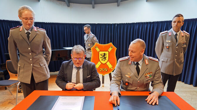 Bürgermeister Mike Münzing und Kommandeur Oberstleutnant Kevin Freudenberger beim Unterzeichnen der Urkunden.  FOTO: LENK
