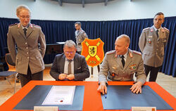 Bürgermeister Mike Münzing und Kommandeur Oberstleutnant Kevin Freudenberger beim Unterzeichnen der Urkunden.  FOTO: LENK