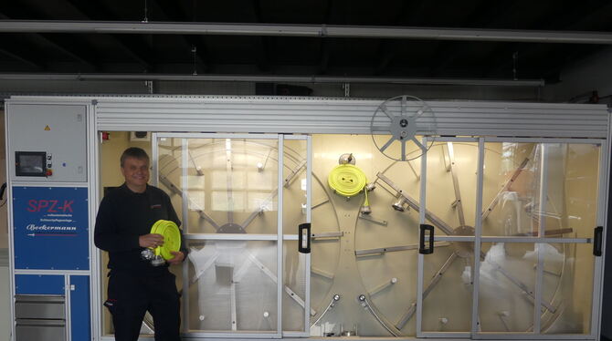 Rübgartens Abteilungskommandant Friedhelm Laux hält einen C-Schlauch in der Hand. Dieser ist 15 Meter lang. Die Waschanlage rein