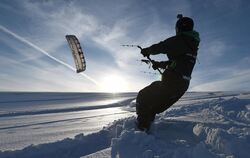 Snowkiter Ronny lässt sich in Heiligenberg auf seinem Snowboard von einen Drachen über den frischen Schnee ziehen.