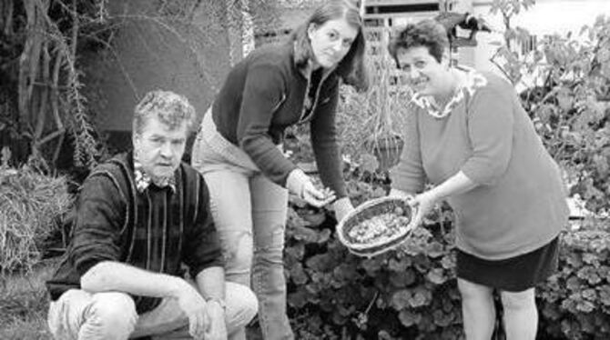 Mit den Zwiebeln, die in den Boden sollen (von links): Ewald, Ellen und Erika Schlotterbeck.
FOTO: KABLAOUI