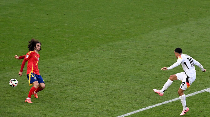 Spaniens Marc Cucurella (links) bekommt den Schuss von Jamal Musiala an die linke Hand.