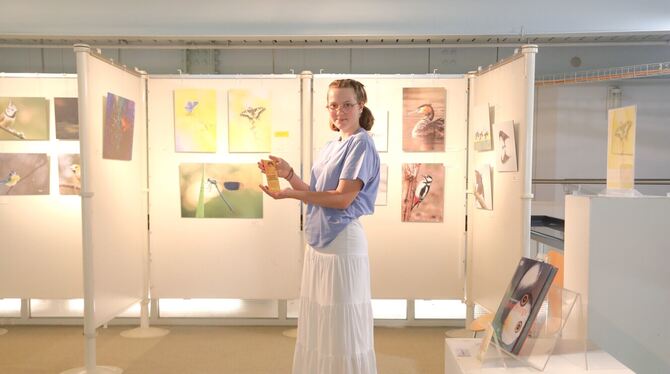 Die junge  Galeriebesucherin Charlotte präsentiert stolz ihr  Saatgut-Lesezeichen, das sie beim Durchstöbern  der Bücher  gefund