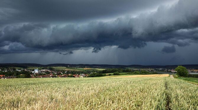Eine Gewitterzelle mit dunklen Wolken baut sich am Himmel auf