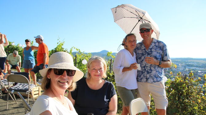 Man muss sich bei der Hitze nur zu helfen wissen: Gut beschirmt lässt es sich im Weinberg bestens feiern.