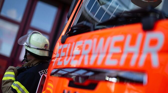 Feuerwehrmann steht neben einem Feuerwehrauto Feuerwehrmann steht neben einem Feuerwehrauto