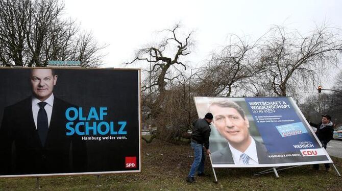 Mitarbeiter einer Werbefirma bauen in Hamburg ein Großplakat der CDU mit Spitzenkandidat Dietrich Wersich ab. Foto: Christian