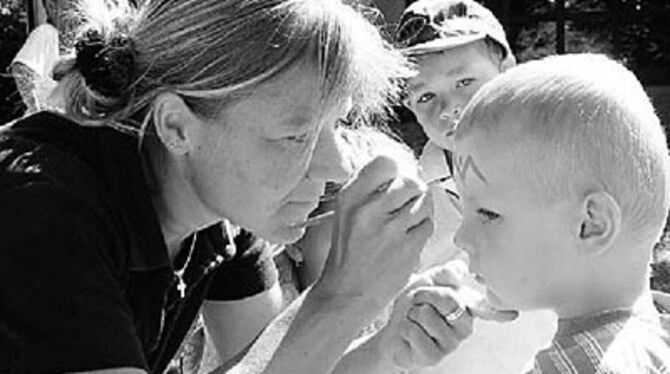 Jonas lässt sich von Beate Bittner in einen Indianer verwandeln.
GEA-FOTO: GEIGER