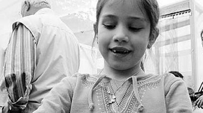 Ganz vorsichtig: Junge Besucherin mit Schwalbenschwanz.
GEA-FOTO: ALP&Agrave;R