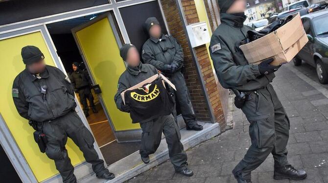 Polizisten tragen in Duisburg bei einer Durchsuchung des Vereinsheims des Rockerclubs »Satudarah Maluku MC« Beweismaterial aus d