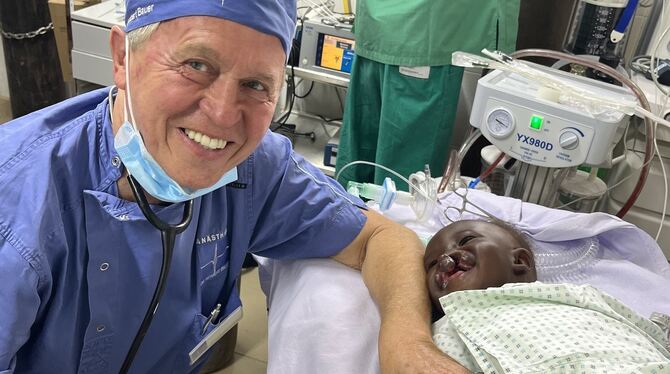 Herbert Bauer mit einem kleinen Patienten am OP-Tisch.