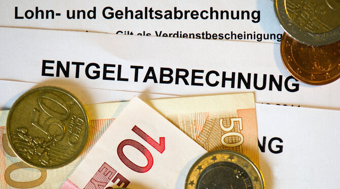 lsn, san, Arbeit, Soziales Auf Lohn- und Gehaltsabrechnungen (Entgeltabrechnungen) liegen Euromünzen und Eurogeldscheine.