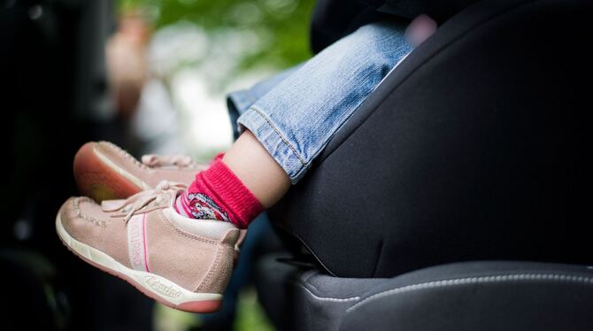 Mädchen sitzt in einem Kindersitz im Auto