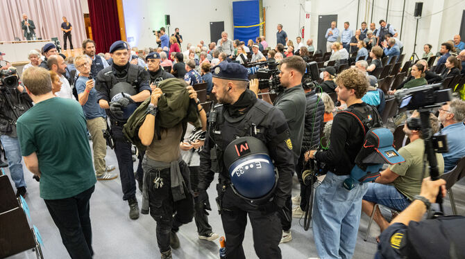 Eine Störerin wird von der Polizei aus dem Saal geleitet. Eine knappe Dreiviertelstunde waren die Beamten damit beschäftigt, Ruh