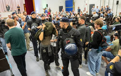 Eine Störerin wird von der Polizei aus dem Saal geleitet. Eine knappe Dreiviertelstunde waren die Beamten damit beschäftigt, Ruh