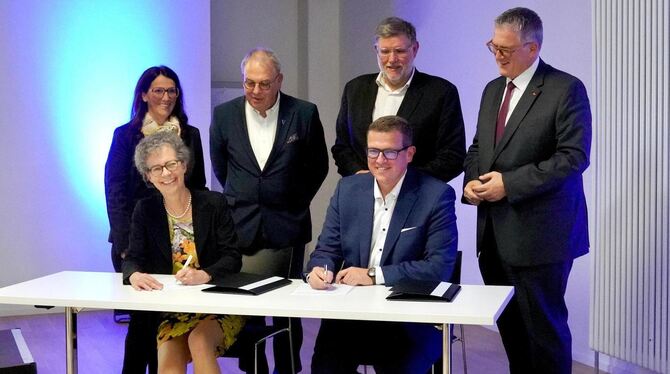 Hochschul-Präsidentin Professor Dr. Sabine Löbbe (links) und Klinik-Geschäftsführer Dominik Nusser besiegeln im Beisein prominen