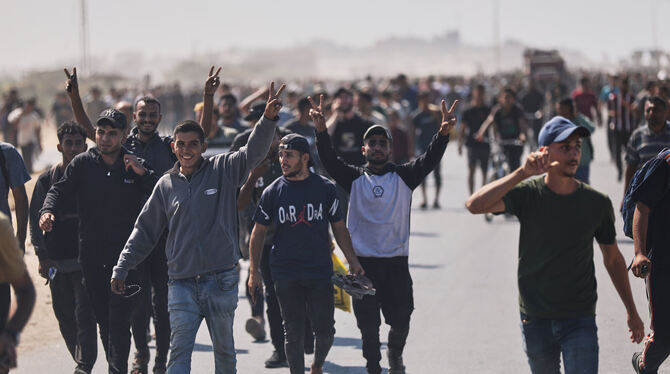 Gaza, Israel, Nahost, Krieg, Konflikte Vertriebene Palästinenser winken in die Kamera, während sie die Küstenstraße in Richtung Gaza im nördlichen Gazastreifen entlang