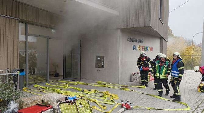 Vor dem Gebäude bereiten sich die Feuerwehrleute für ihren Einsarz vor, die Führungskräfte beobachten und planen die nächsten Ma
