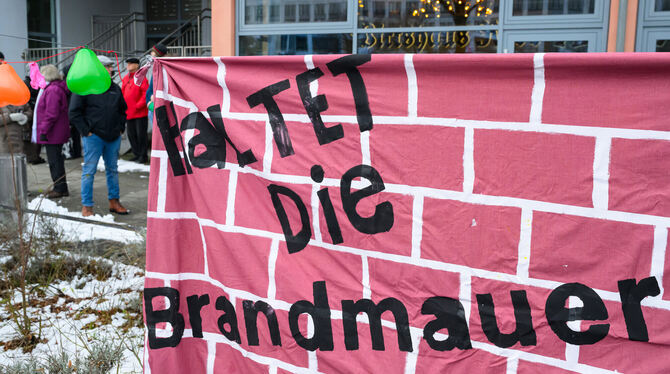 Ein Transparent mit der Aufschrift »Haltet die Brandmauer« hängt auf der Kundgebung »Liebe statt Hass«.