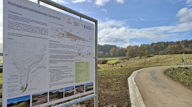 Ein Hinweisschild informiert über Funktion und technische Daten des Hochwasserrückhaltebeckens.