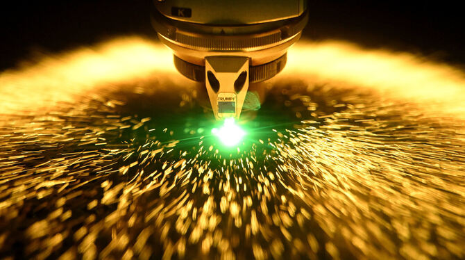 Ein Laser schneidet im Besucherzentrum des Maschinenbauers Trumpf in ein Blech.